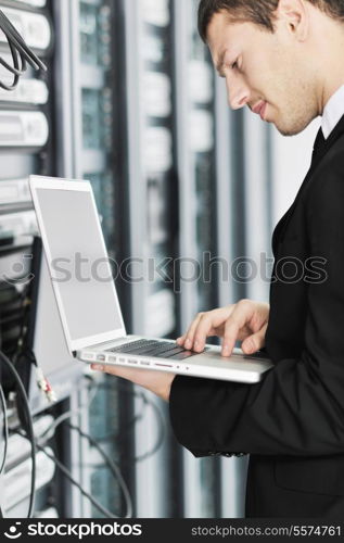 young it engeneer business man with thin modern aluminium laptop in network server room