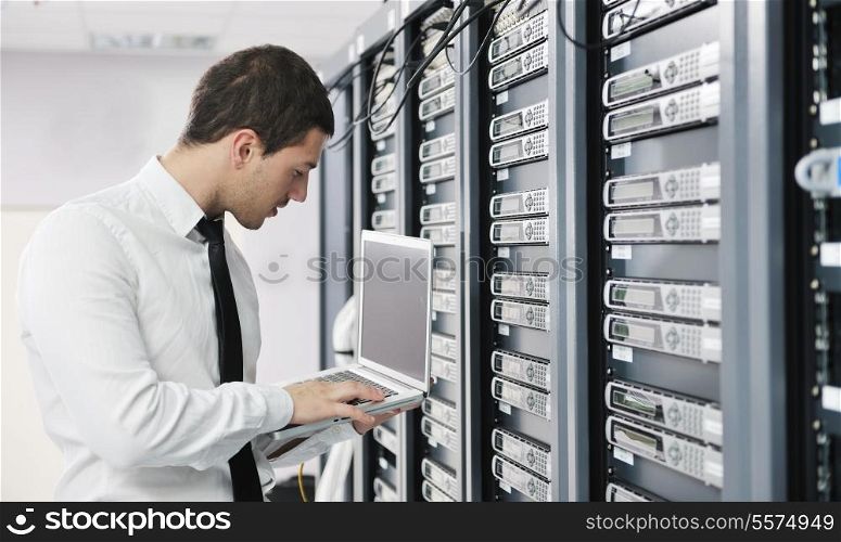 young it engeneer business man with thin modern aluminium laptop in network server room