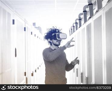 young IT engeneer using virtual reality headset over server room background