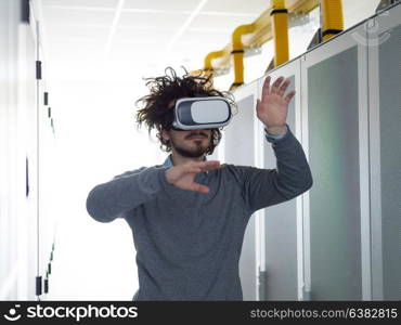 young IT engeneer using virtual reality headset over server room background