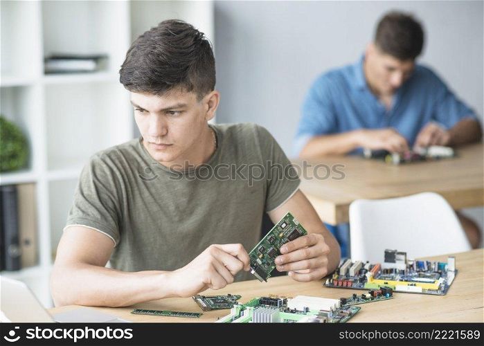 young it student practicing hardware equipment s workbench