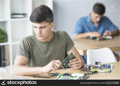 young it student practicing hardware equipment s workbench