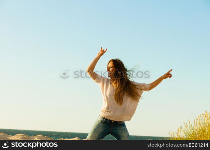 Young joyful girl on beach.. Joy and carefree. Gorgeous long haired woman having fun on beach. Young joyful attractive girl feels freedom. Summer time.