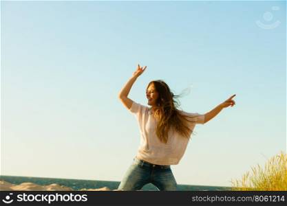 Young joyful girl on beach.. Joy and carefree. Gorgeous long haired woman having fun on beach. Young joyful attractive girl feels freedom. Summer time.
