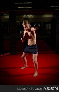 Young kickboxer training at gym