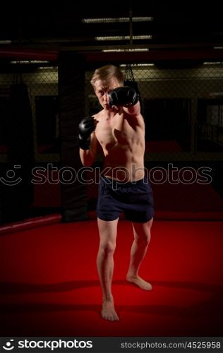 Young kickboxer training at gym