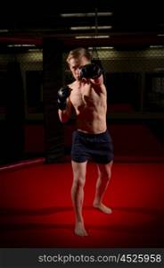 Young kickboxer training at gym
