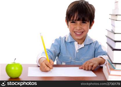 Young kid enjoying art as he draws on blank sheet of paper