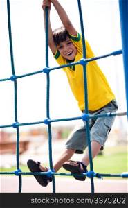 Young kid on playstructure, outdoors