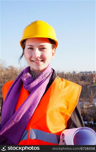 Young lady architect staying outdoors against blue sky