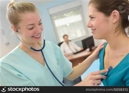young lady doctor with stethoscope and patient in a surgery