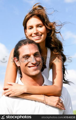 Young lady embracing her man and smiling at camera