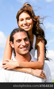 Young lady embracing her man and smiling at camera