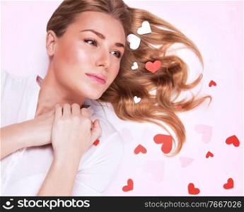 Young lady in love, closeup fashionable portrait, lying down, beautiful glossy hair, many little hearts decor, Valentine day concept