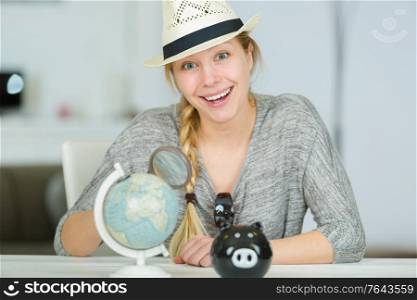 young lady looking at globe through a magnifying glass