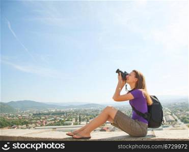 Young lady photographer shooting outdoors