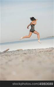 Young lady running on a beach during sunrise