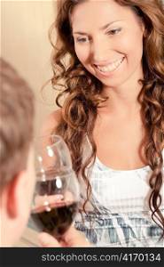 Young lady smiling while sharing a drink with her man