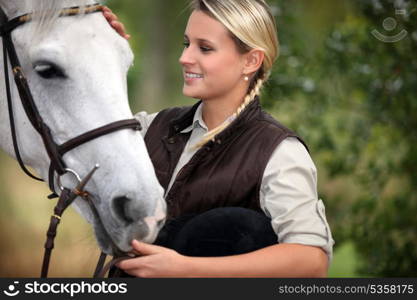 Young lady stroking her horse
