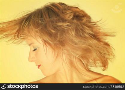 young lady turning her head, over yellow background