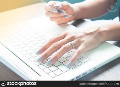 Young lady using laptop and credit card for online shopping