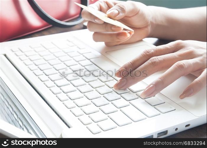 Young lady using laptop and holding credit card, Online shopping concept