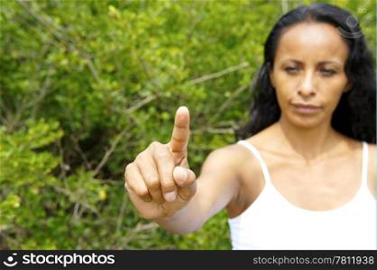 Young latin woman pointing with a finger in the air.