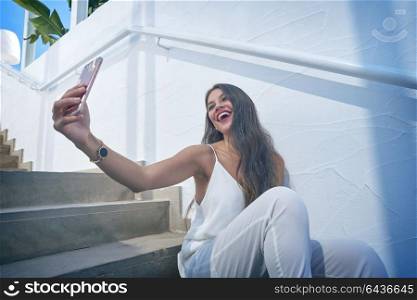 Young latin woman selfie photo smarphone in a white stairway outdoor