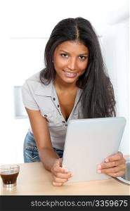 Young latin woman using electronic tablet in home kitchen