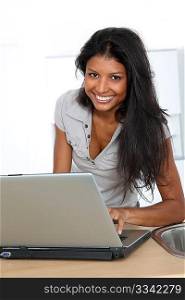 Young latin woman using laptop computer in home kitchen