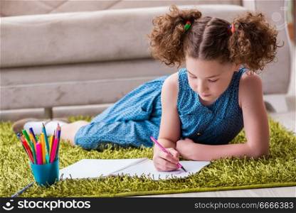 Young little girl drawing on paper with pencils