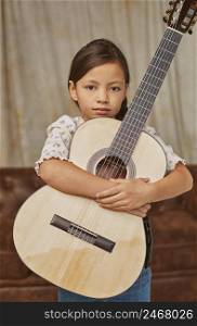 young little girl playing guitar home