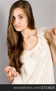Young long-haired girl on gray background