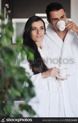 Young love couple taking fresh morning cup of coffee in the modern appartment