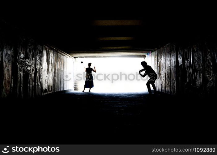 Young lovely couple taking selfies in an underground passage.