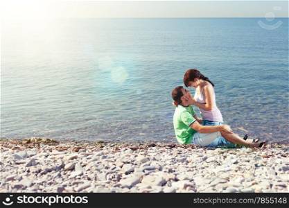 Young lovers playing on the beach, lens flares