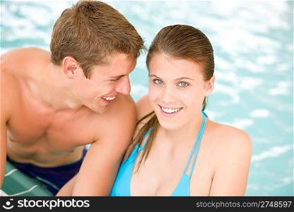 Young loving couple have fun in swimming pool in luxury hotel