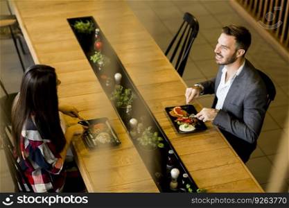 Young loving couple having lunch in the modern restaurant