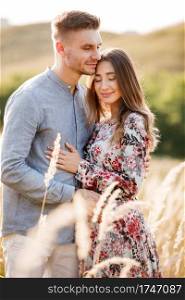 young loving couple hugging outdoors in the field on summer. concept of happiness and love. close up photo. love story.. young loving couple hugging outdoors in the field on summer. concept of happiness and love. close up photo. love story