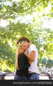 Young loving couple share hug outside