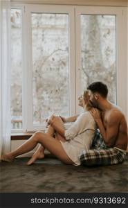 Young loving couple sitting on the floor in the room