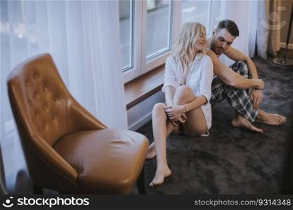 Young loving couple sitting on the floor in the room