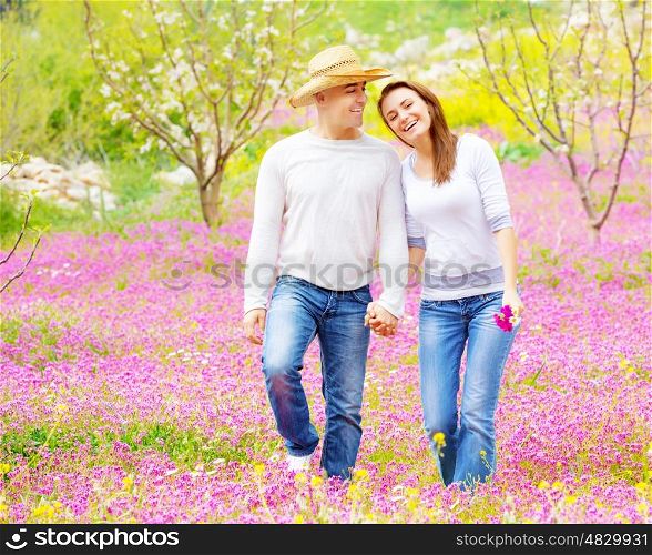 Young loving couple walk in spring park, first love, romantic date, springtime holidays, spending time together outdoors