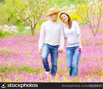 Young loving couple walk in spring park, first love, romantic date, springtime holidays, spending time together outdoors