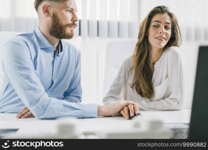 Young male and female colleagues having a romantic affair at Work. Workplace Relationship.