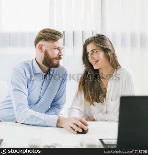 Young male and female colleagues having a romantic affair at Work. Workplace Relationship.. Office Romance. Colleagues Flirting at a Workplace