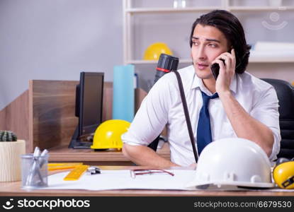 Young male architect working in the office 