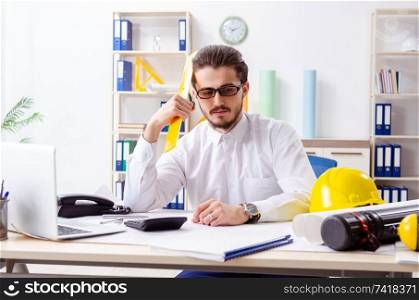 Young male architect working in the office 