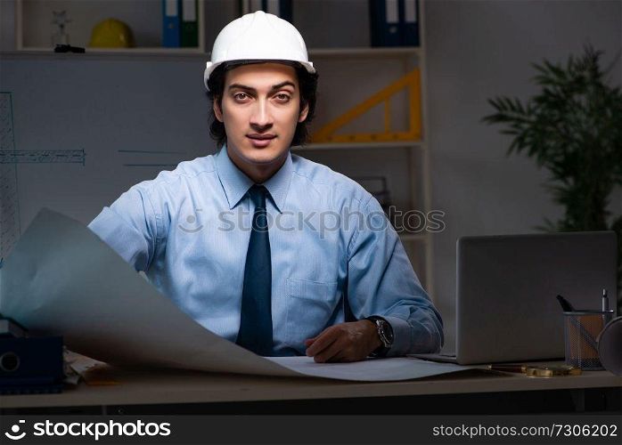 Young male architect working night at office 