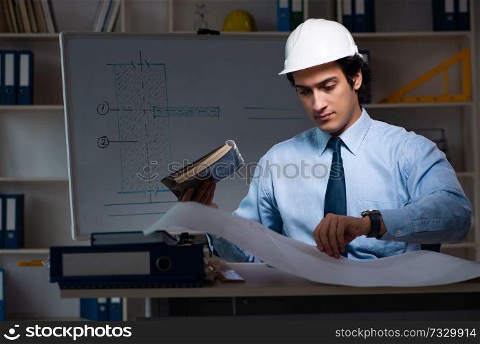 Young male architect working night at office 